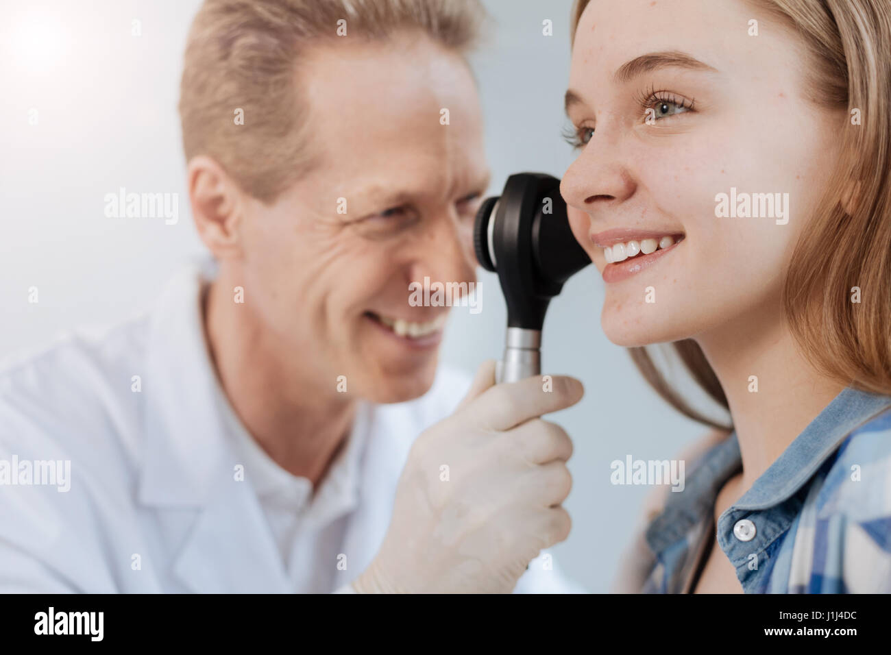 Optimistische Dermatologen mit Dermatoskop bei der Arbeit Stockfoto