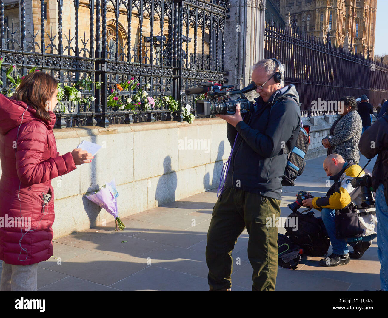 Schmierfilmbildung Medien Interview neben floralen Ehrungen nach dem Westminster Terroranschlag, Parliament Square, London, England Stockfoto