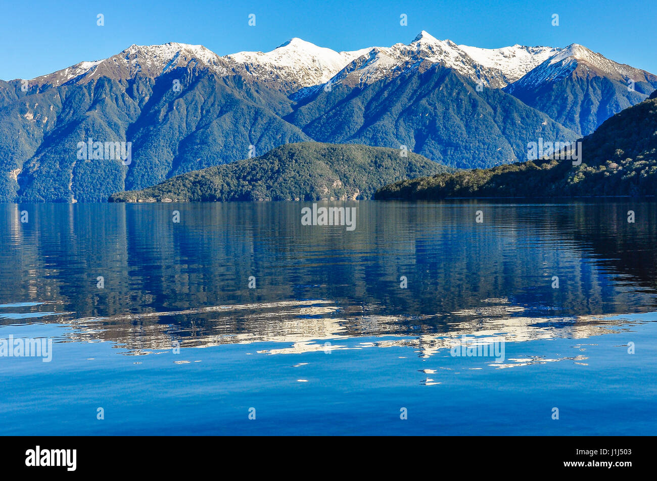 Reflexion der schneebedeckten Berge im Lake Hauroko in der Southern Scenic Route, Neuseeland Stockfoto