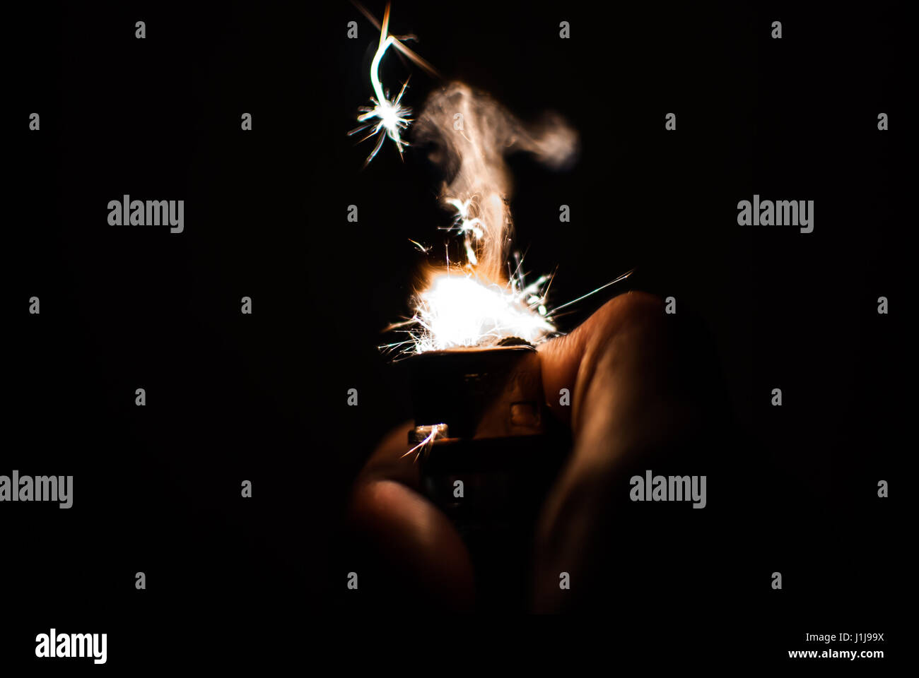 Hand mit Feuerzeug auf schwarzen Hintergrund abgeschnitten Stockfoto