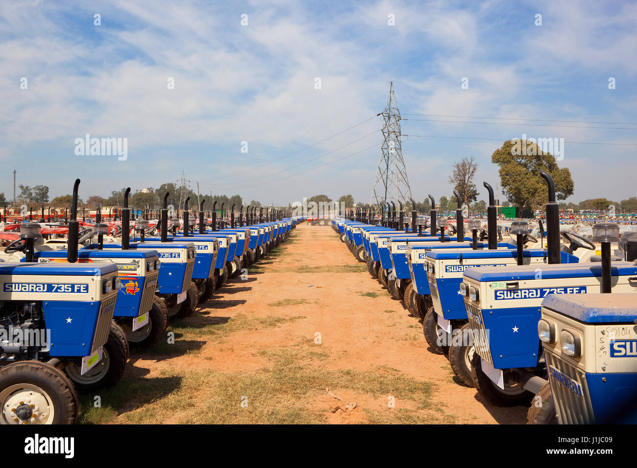 Reihen von neuen Traktoren in einer Fabrik in Chandigarh Punjab Indien bei bewölktem Himmel blau Stockfoto