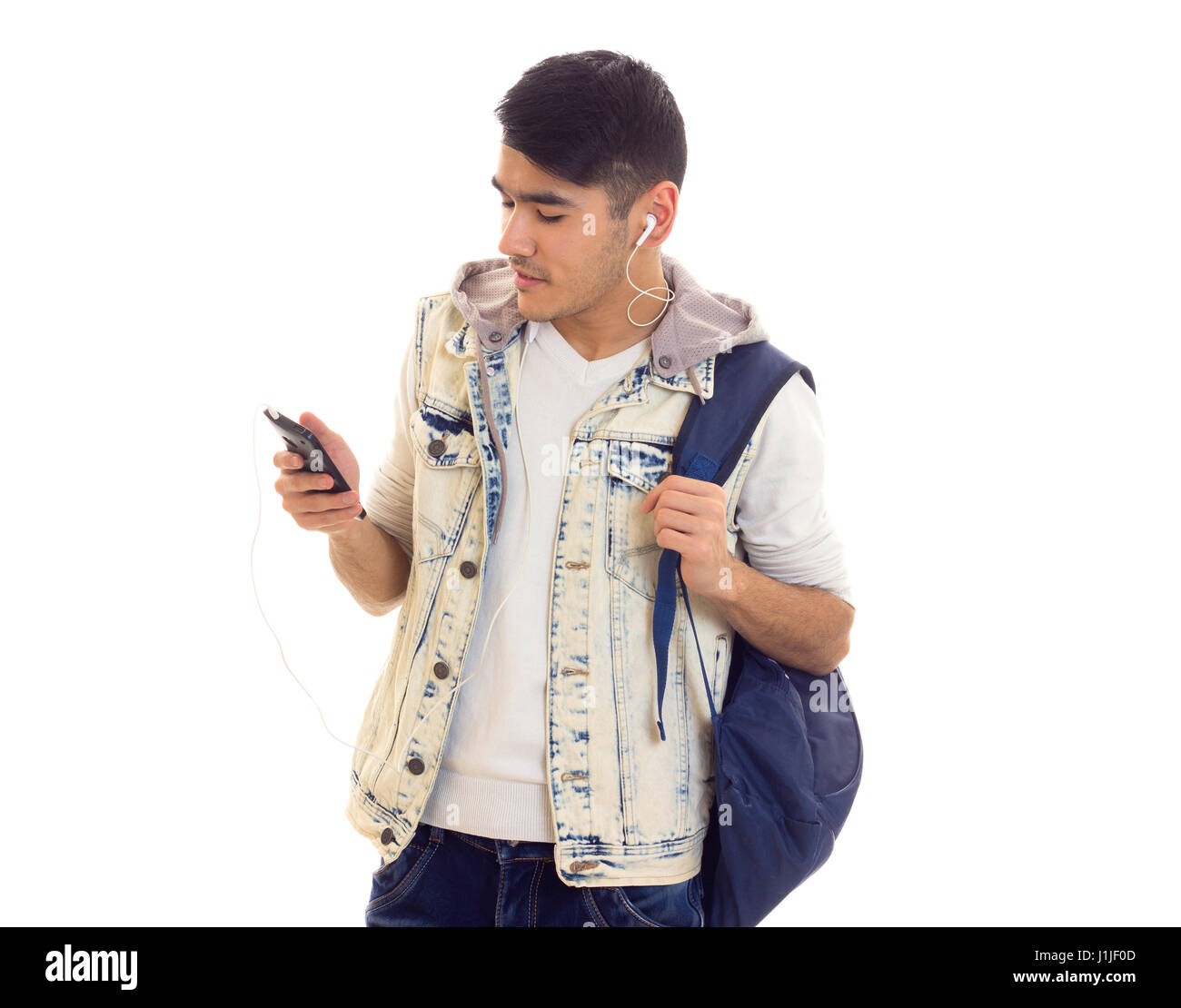 Junger Mann mit Rucksack, Smartphone und Kopfhörer Stockfoto