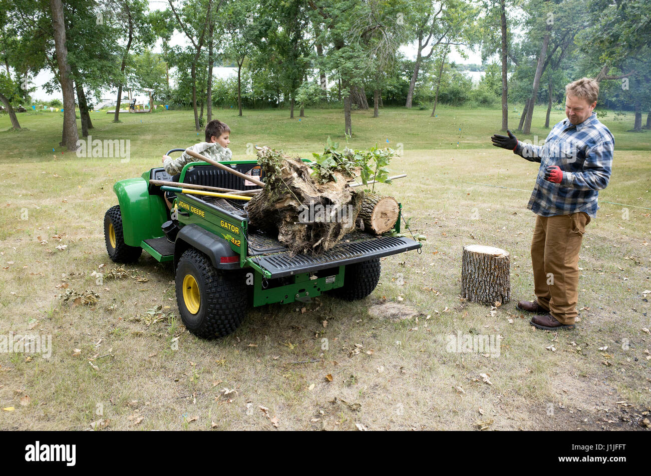 Vater Regie Sohn Gator mit Logs sichern. Clitherall Minnesota MN USA Stockfoto