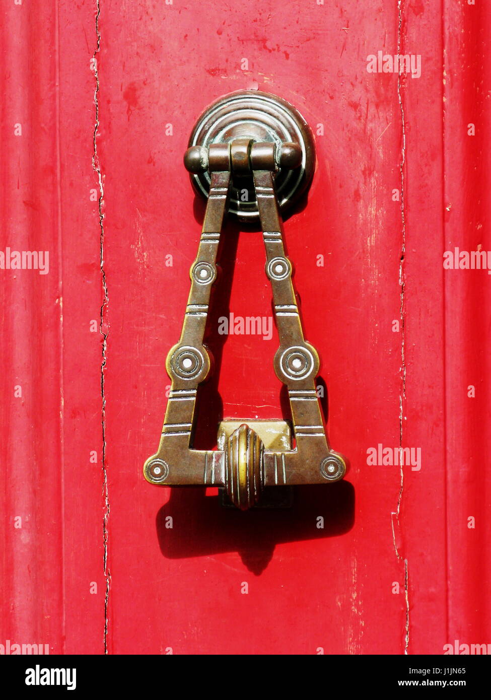 Ein Türklopfer Messing auf eine rote Tür Stockfoto