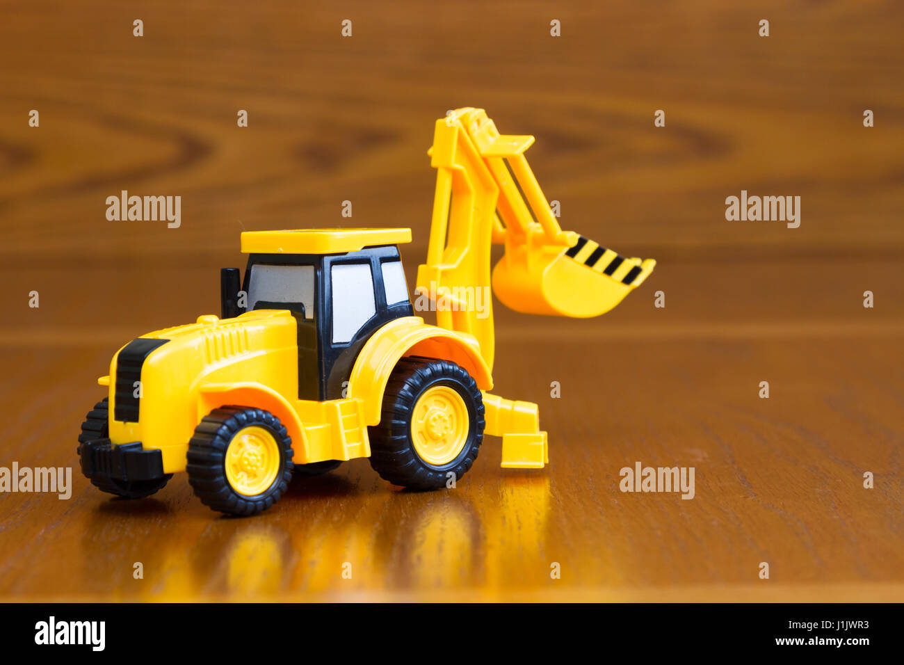 Kinder Traktor gelb auf einem braunen Hintergrund-Makro Stockfoto