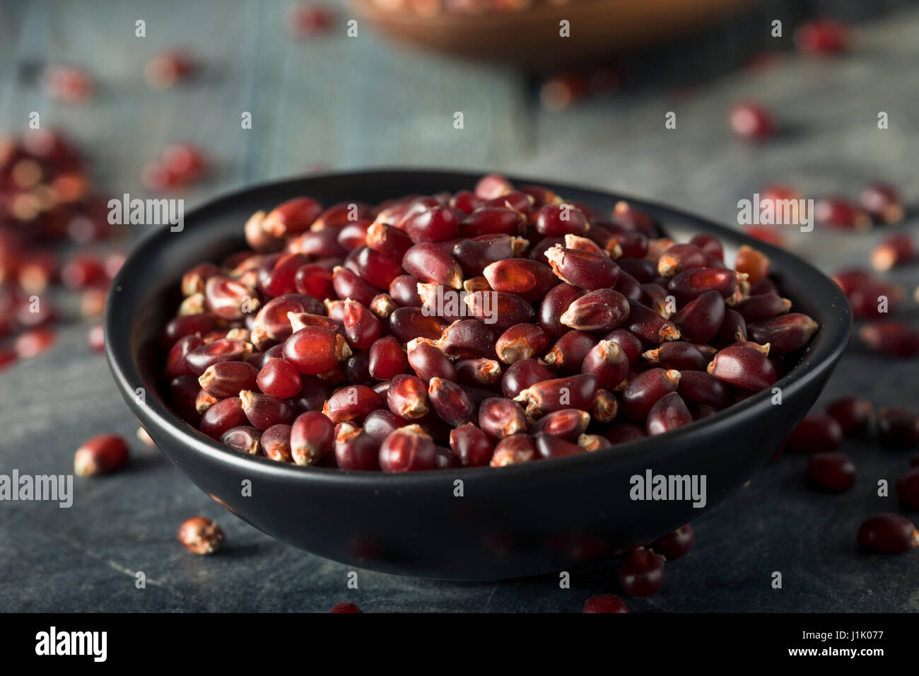 Rohe Bio Rubin Rot Popcorn in eine Schüssel geben Stockfoto