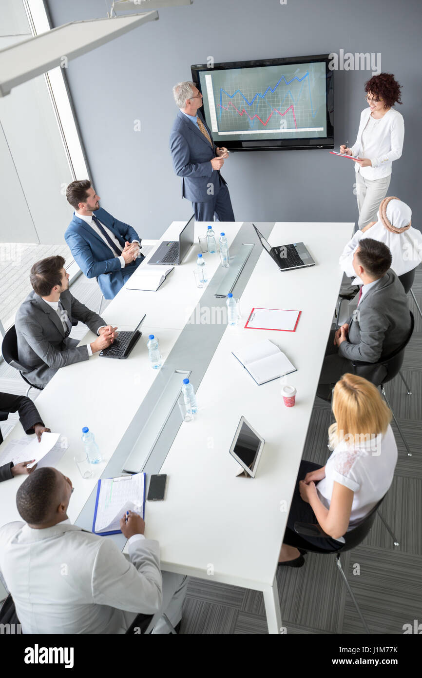Arbeitnehmer-Gruppe am Besprechungstisch Managers Zukunftsplan zu hören, während seine Assistentin Notizen Stockfoto