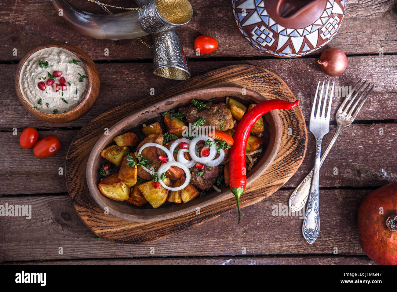 Mariniertes gebratenes Schweinefleisch und Kartoffeln mit Walnuss-Sauce und Wein, georgische Schale Ojahuri. Stockfoto