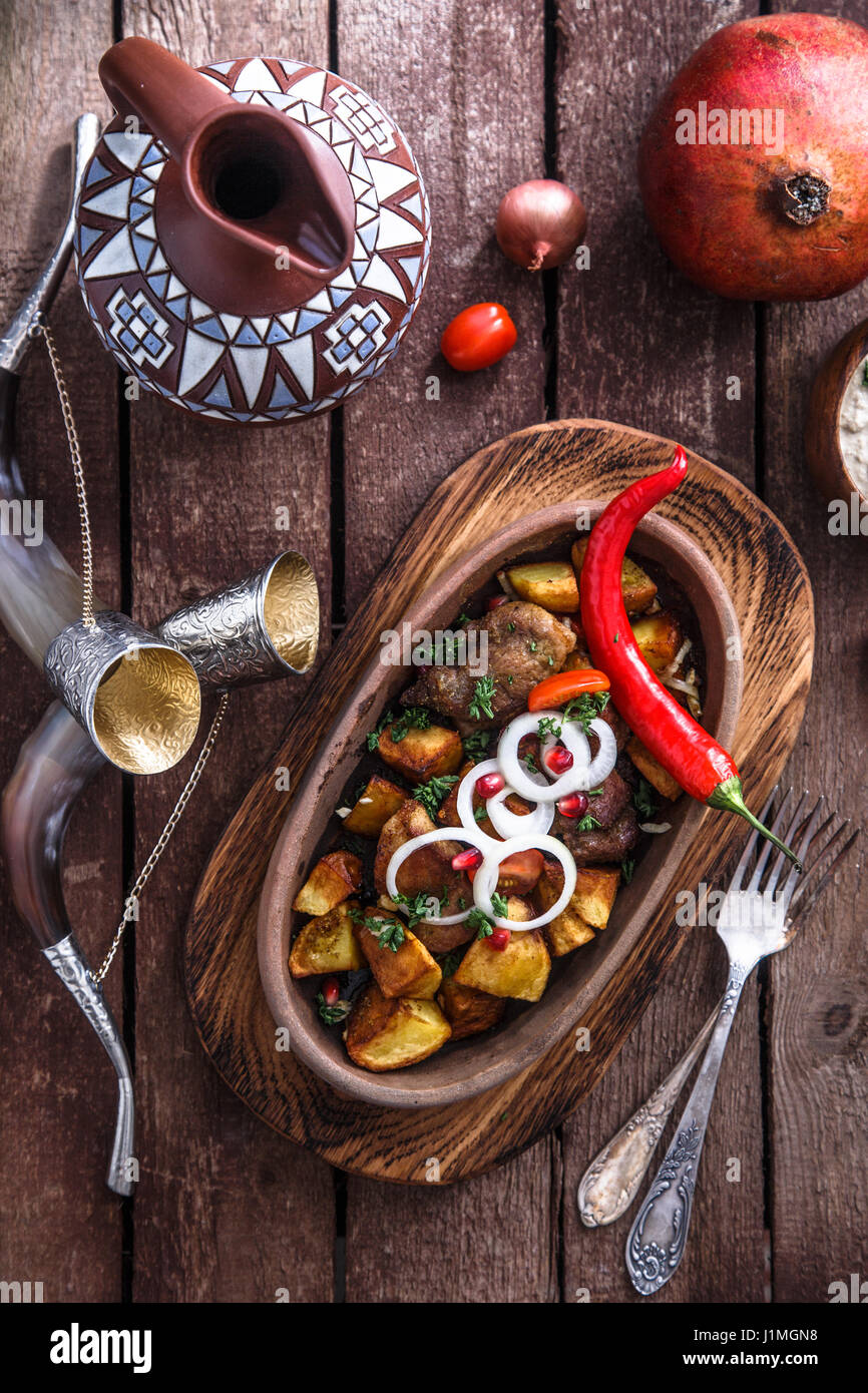Ojaxuri, gebratenes Schweinefleisch und Kartoffeln mit Zwiebeln und Granatapfel Samen. Ansicht von oben Stockfoto