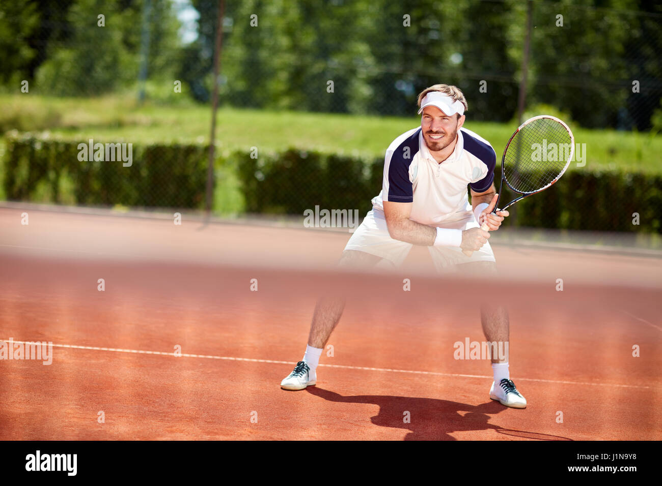 Tennisspieler mit Schläger in Aktion auf Tennisplatz Stockfoto