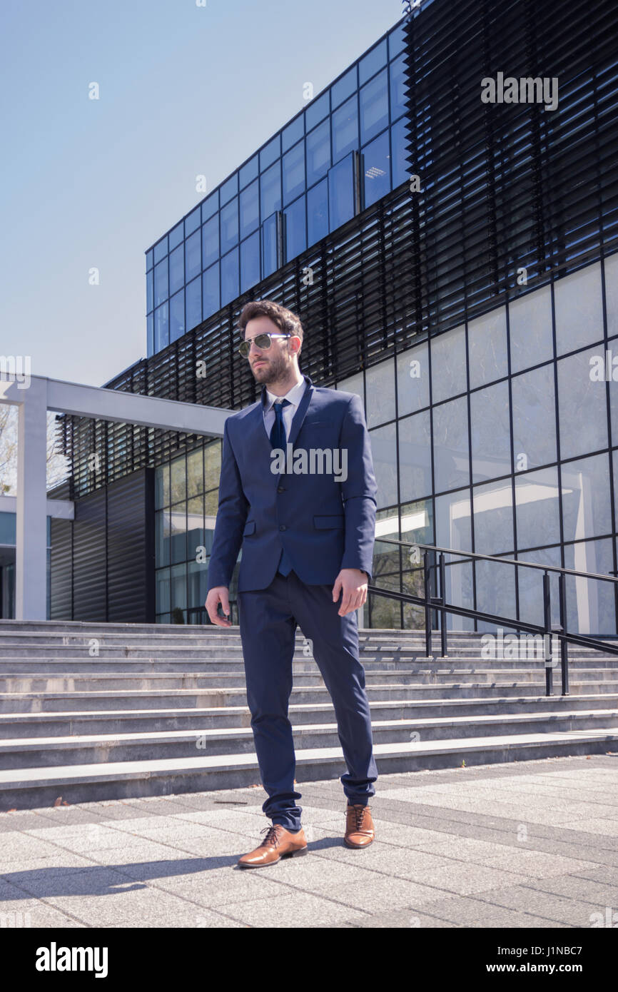 ein junger Mann zu Fuß Anzug Krawatte, moderne Gebäude-Architektur Stockfoto