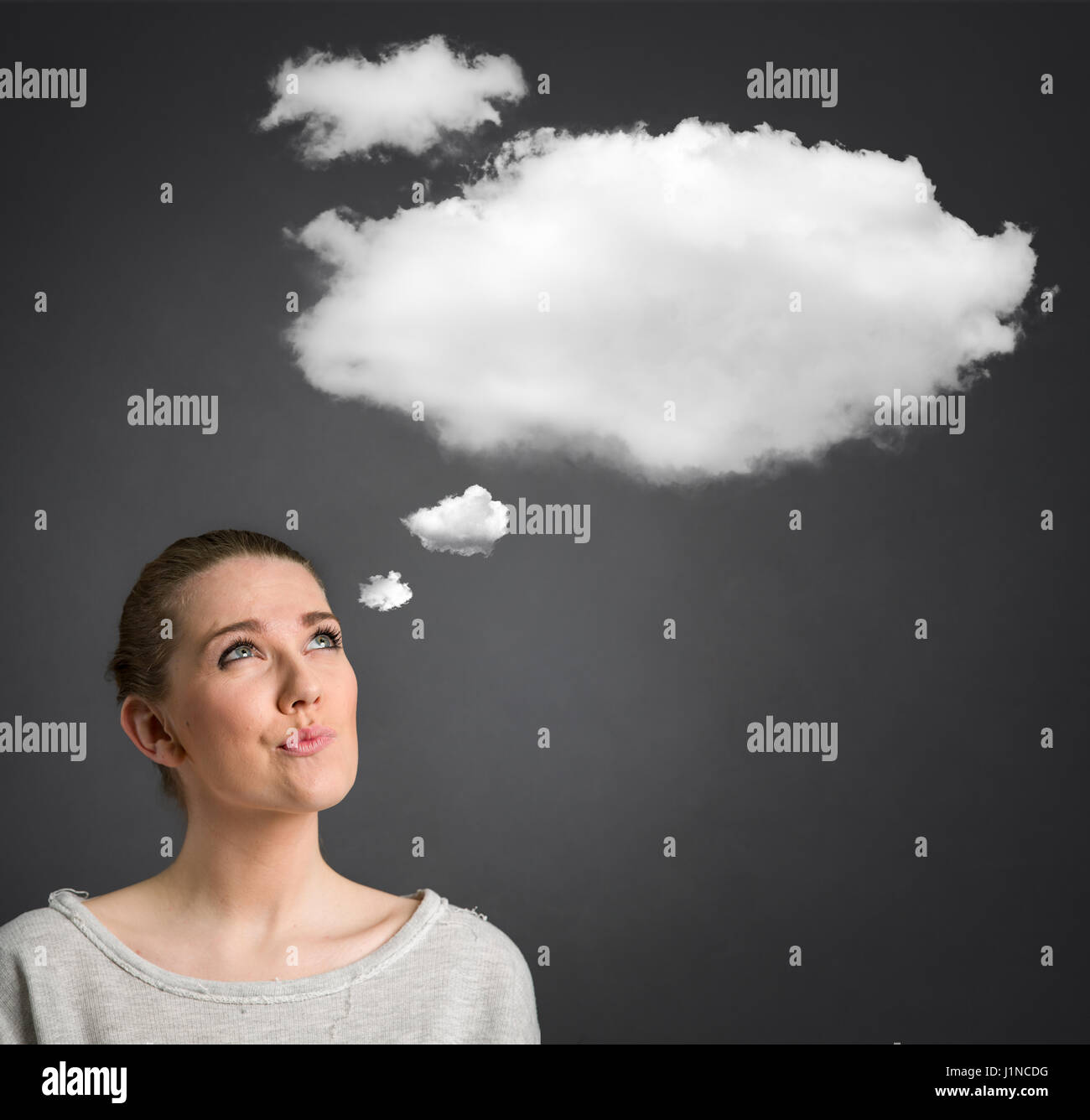 junge Frau sah und dachte über den Kopf mit der cloud Stockfoto