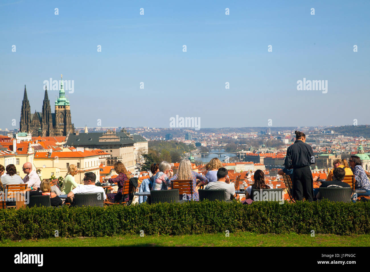 Die Menschen Essen und Trinken außerhalb in einem Restaurant mit Blick über die Stadt von Prag. Stockfoto
