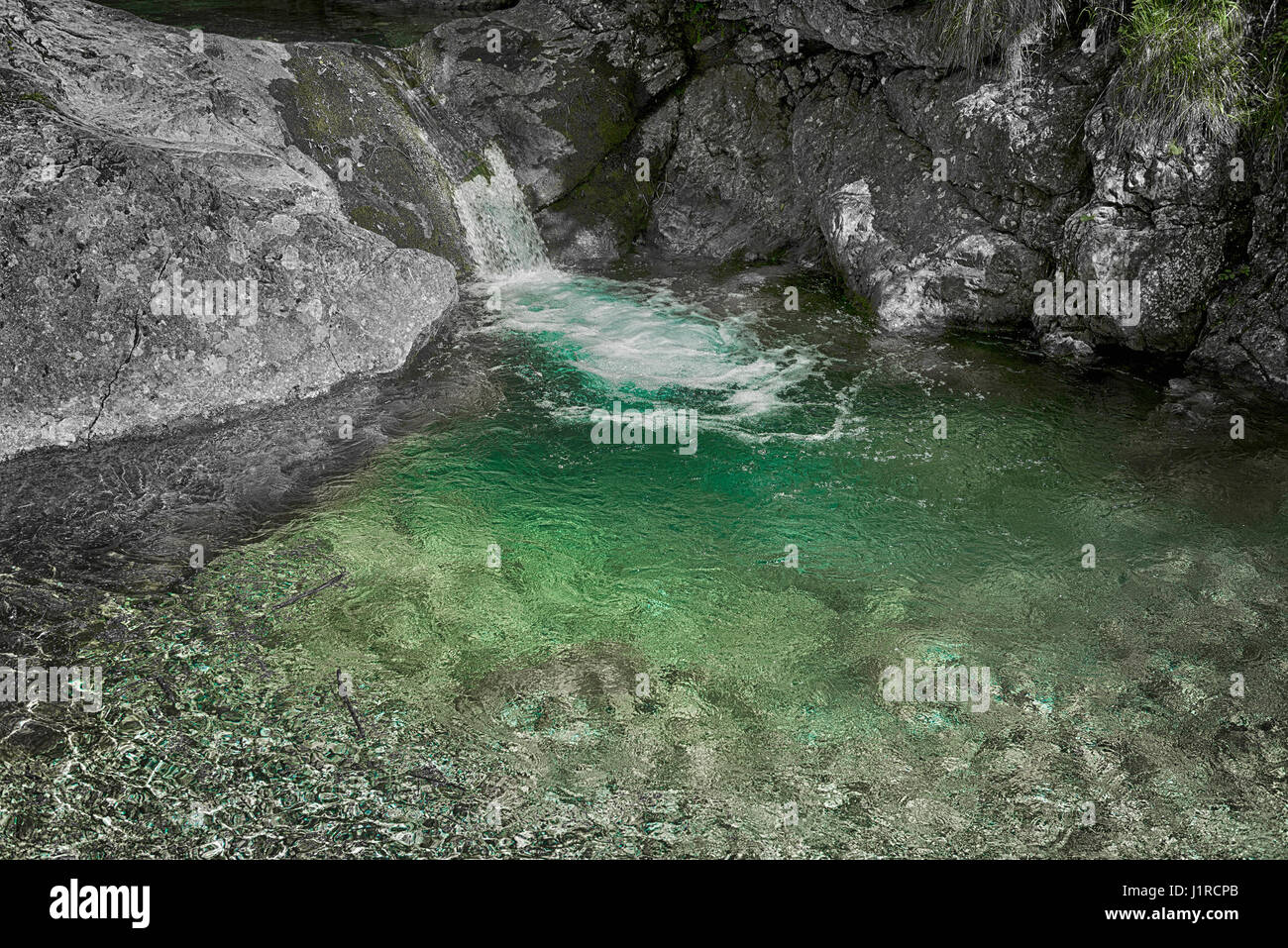 Kristallklarem Wasser von einem Wasserfall umgeben von grauen Felsen, Val Vertova in der Nähe der Stadt Bergamo Stockfoto
