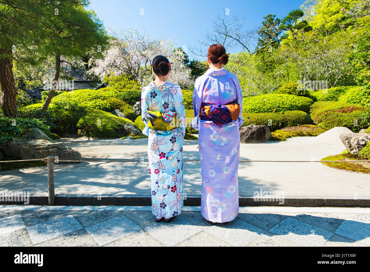 Zwei junge Frauen gekleidet im Yukata stehen vor Arock Garten oder Karesansui in Meigetsu-in-Tempel in Kamakura, Japan Stockfoto