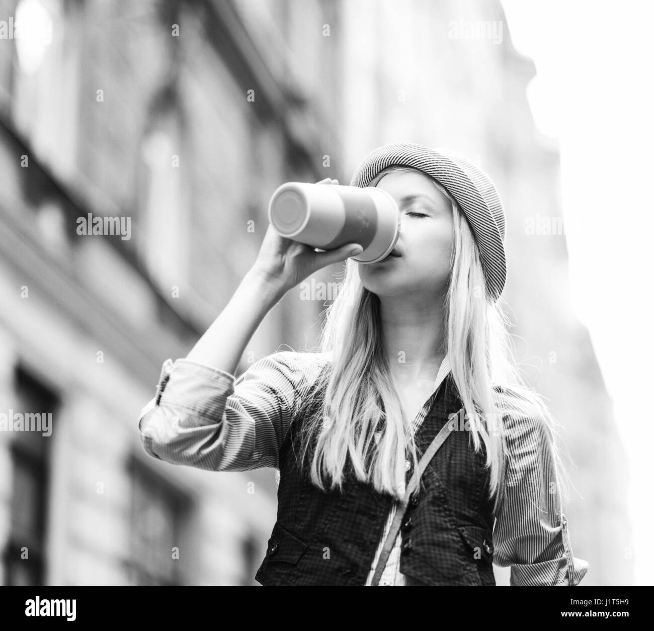 Junge Hipster Tasse Heißgetränk in der Stadt Stockfoto