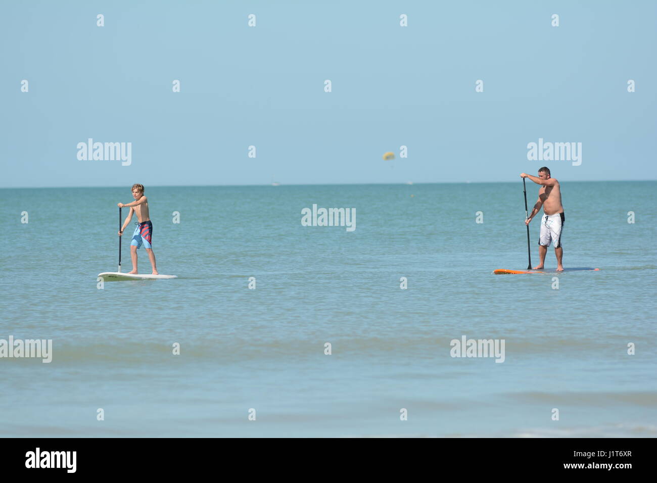 Menschen am Strand und im Meer in Florida paddle-Boarding Stockfoto