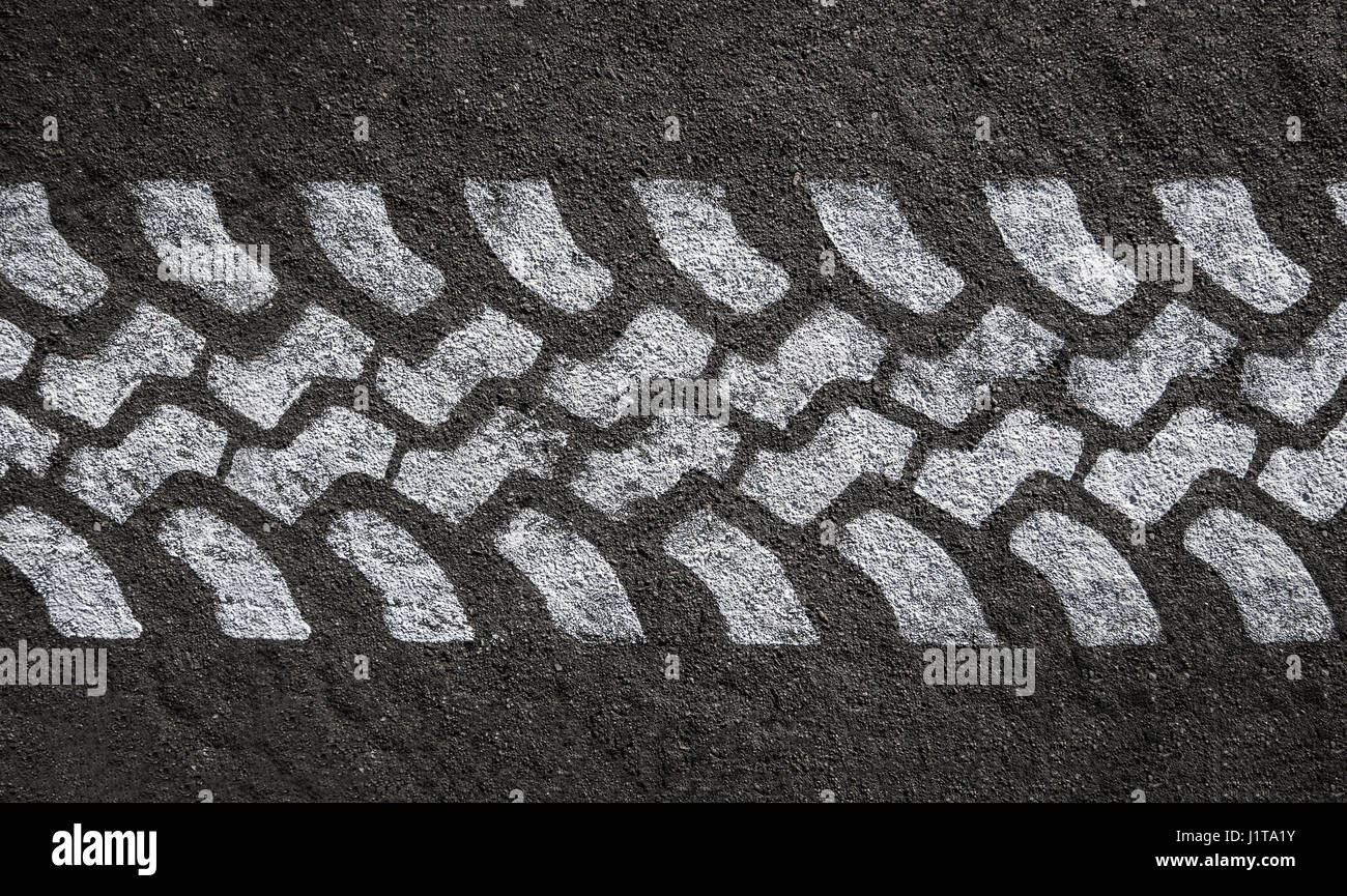 Detail einer weiß lackierten Reifen Spur auf schwarzem Asphalt Stockfoto