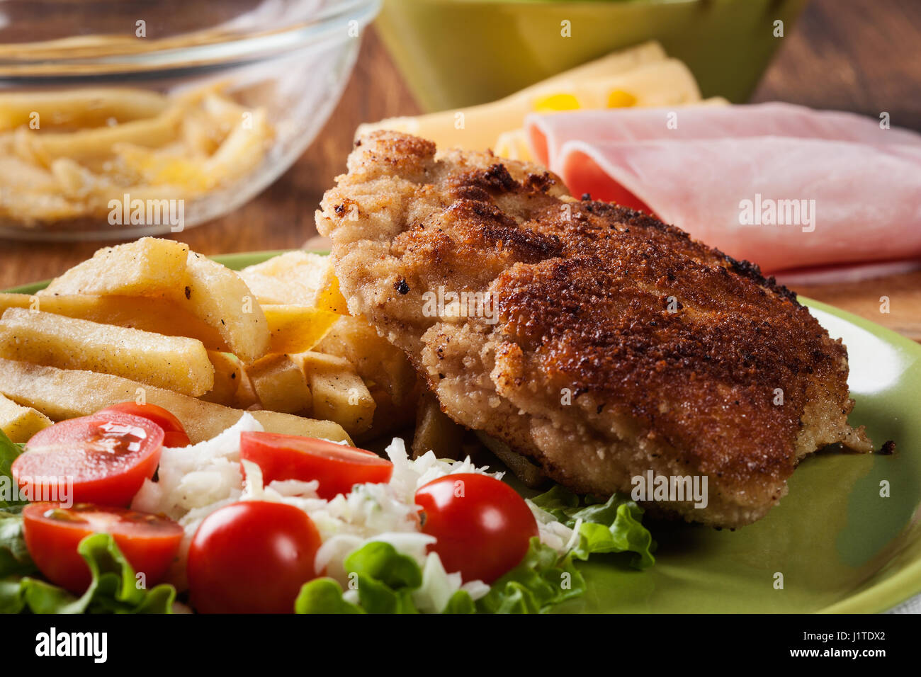 Schnitzel Cordonbleu mit Schweinelende mit Pommes Frites und Salat auf einem Teller serviert Stockfoto