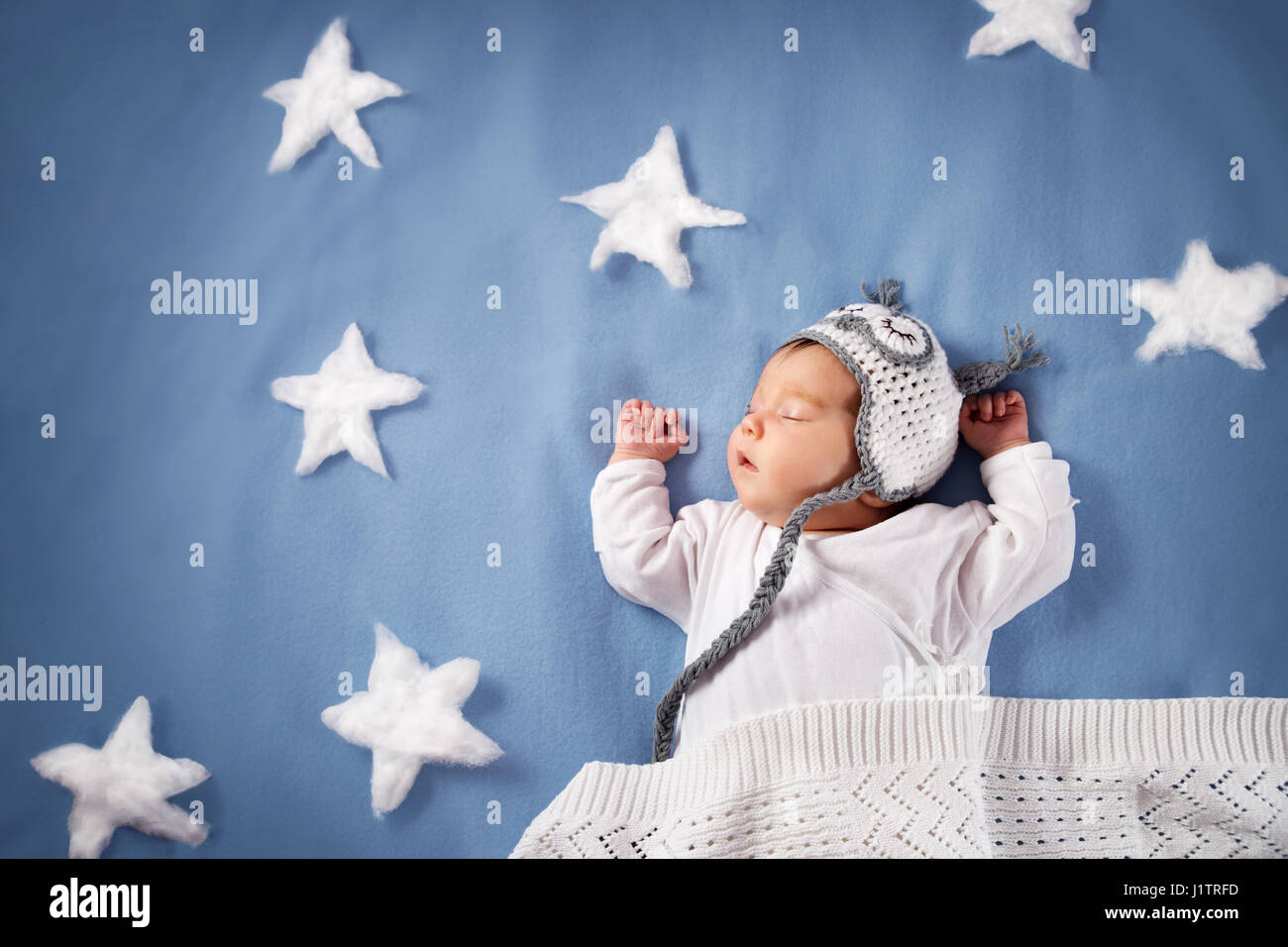 Niedlichen neugeborenen Mädchen im Bett liegend. 2 Monate altes Kind in Owl Hut auf blaue Decke schlafen Stockfoto