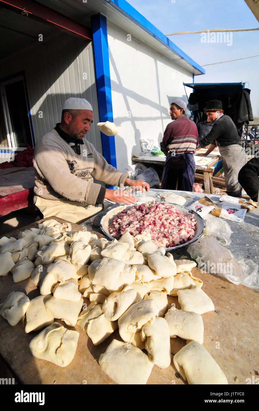 Ein Uyghur Mann Vorbereitung Samsa in einem kleinen Teehaus in tierischen Sonntagsmarkt von Kashgar. Stockfoto
