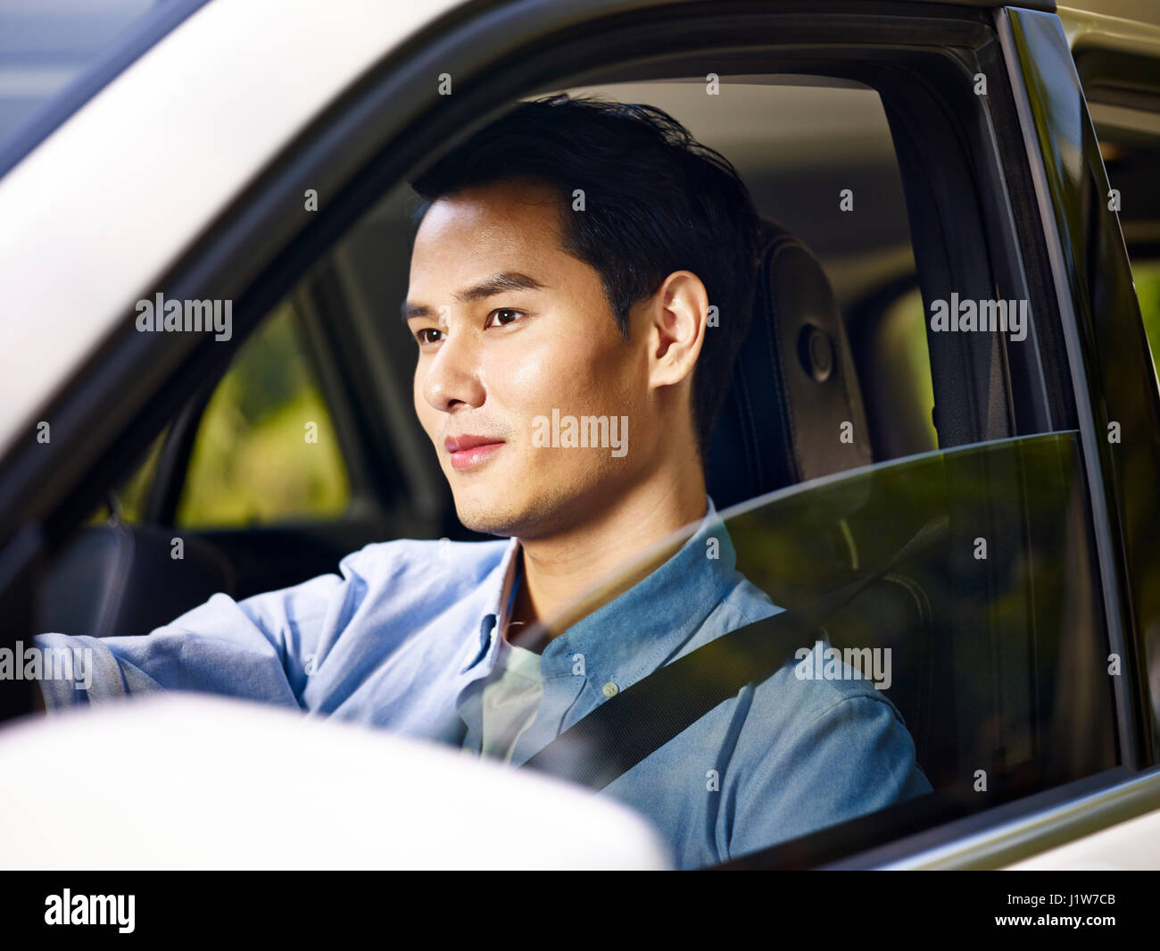 junge asiatische Mann ein Fahrzeug zu fahren. Stockfoto