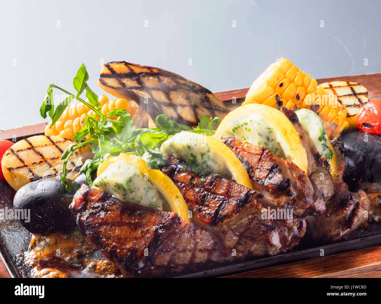 Köstliche Beefsteak mit Mais orange Süßkartoffeln auf hölzernen Platte Stockfoto