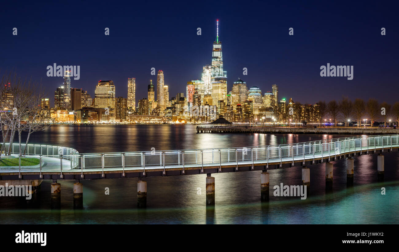 New York City-Financial District Wolkenkratzer und Hudson River von Hoboken Strandpromenade Abend. Lower Manhattan und Fußgängerbrücke aus New Jersey Stockfoto