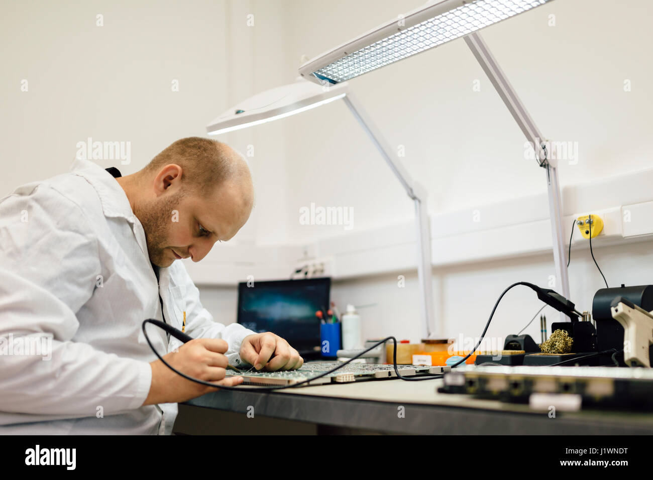 Techniker, die Festsetzung Motherboard durch Löten chips Stockfoto