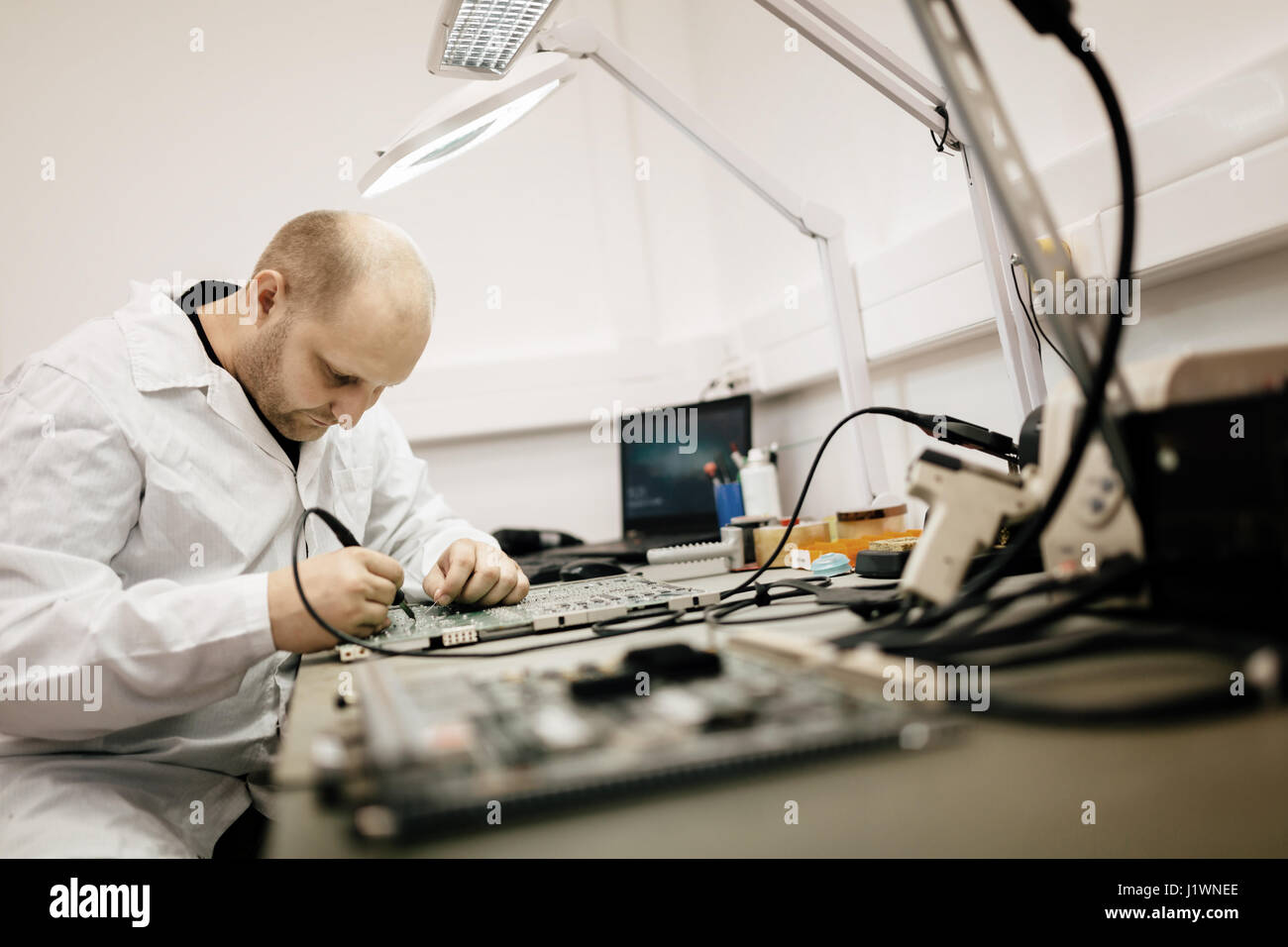 Techniker, die Festsetzung Motherboard durch Löten chips Stockfoto