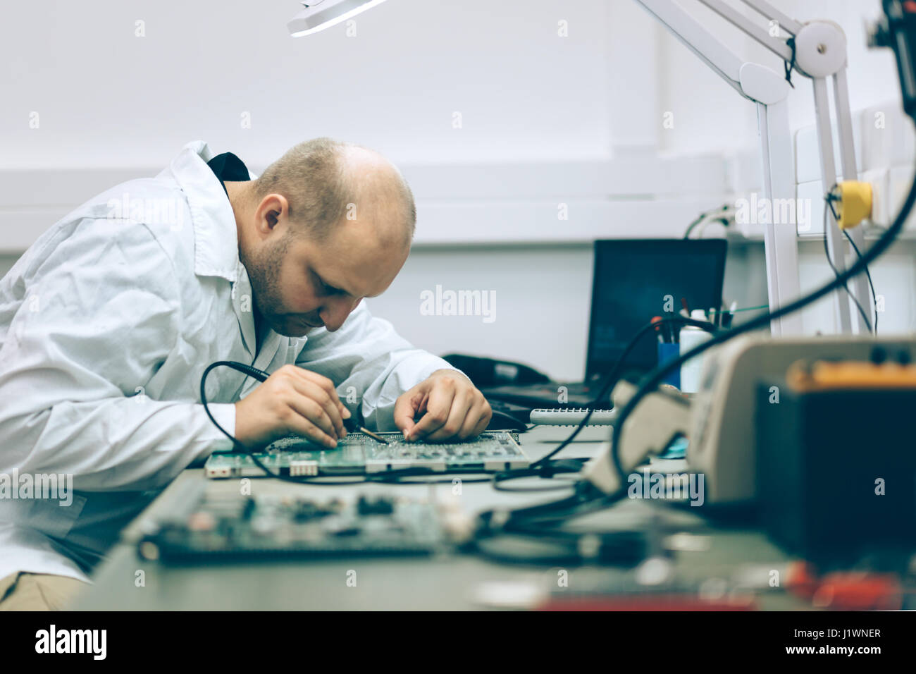 Techniker, die Festsetzung Motherboard durch Löten chips Stockfoto