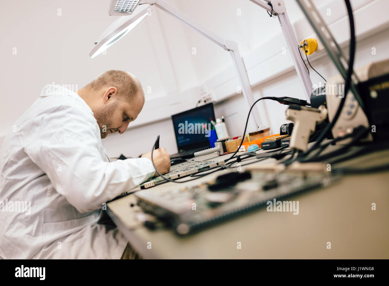 Techniker, die Festsetzung Motherboard durch Löten chips Stockfoto