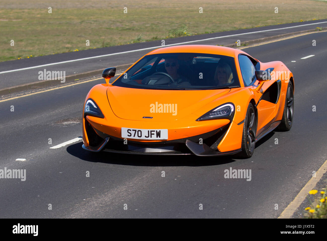 Orange 2017 McLaren 570S Sportwagen Coupe Auto Supercar, Preis ab £143,000, Fahrt entlang Southport Seafront, Merseyside, Großbritannien Stockfoto