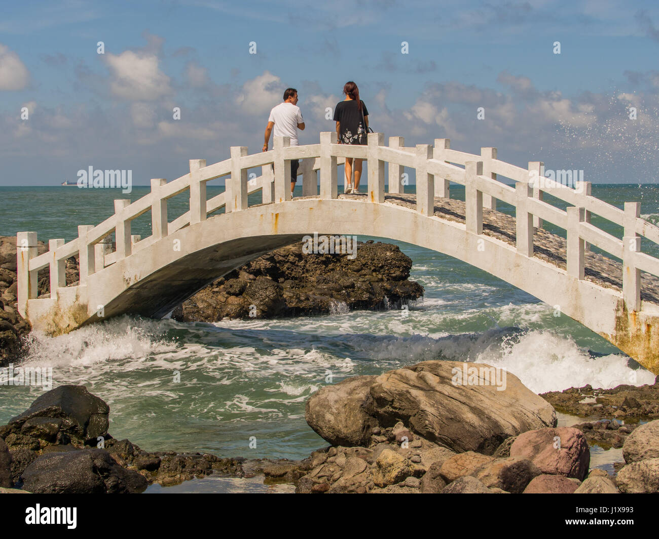 Shimen, Taiwan - 3. Oktober 2016: Eine weiße Brücke zwischen den Felsen am Ufer des Ozeans in Shimen Art, Nordtaiwan Stockfoto