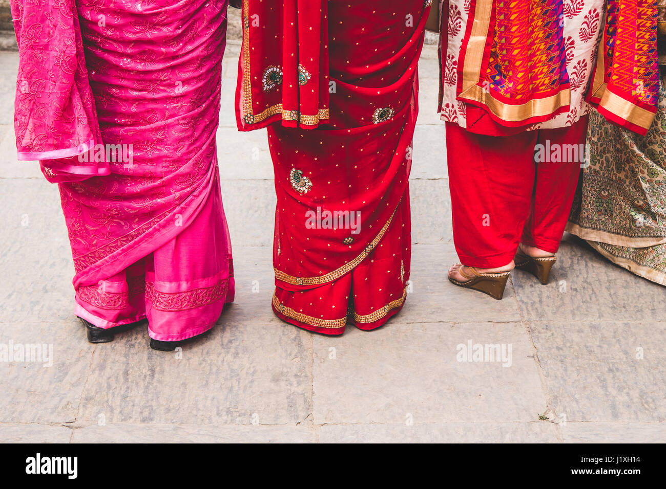 Drei Frauen in bunten Saris gekleidet. Abstrakte Komposition, die auf der Suche nach unten. Stockfoto