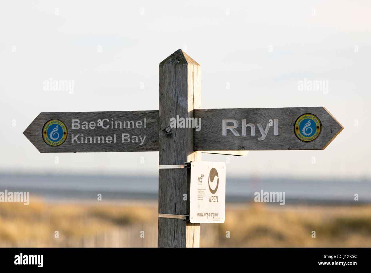 Hölzerne Strand Schild mit den Worten Rhyl und Bae Cinmel Kinmel Bay auf Teil des walisischen Küstenweg in den Badeort Rhyl in Nord-Wales Stockfoto