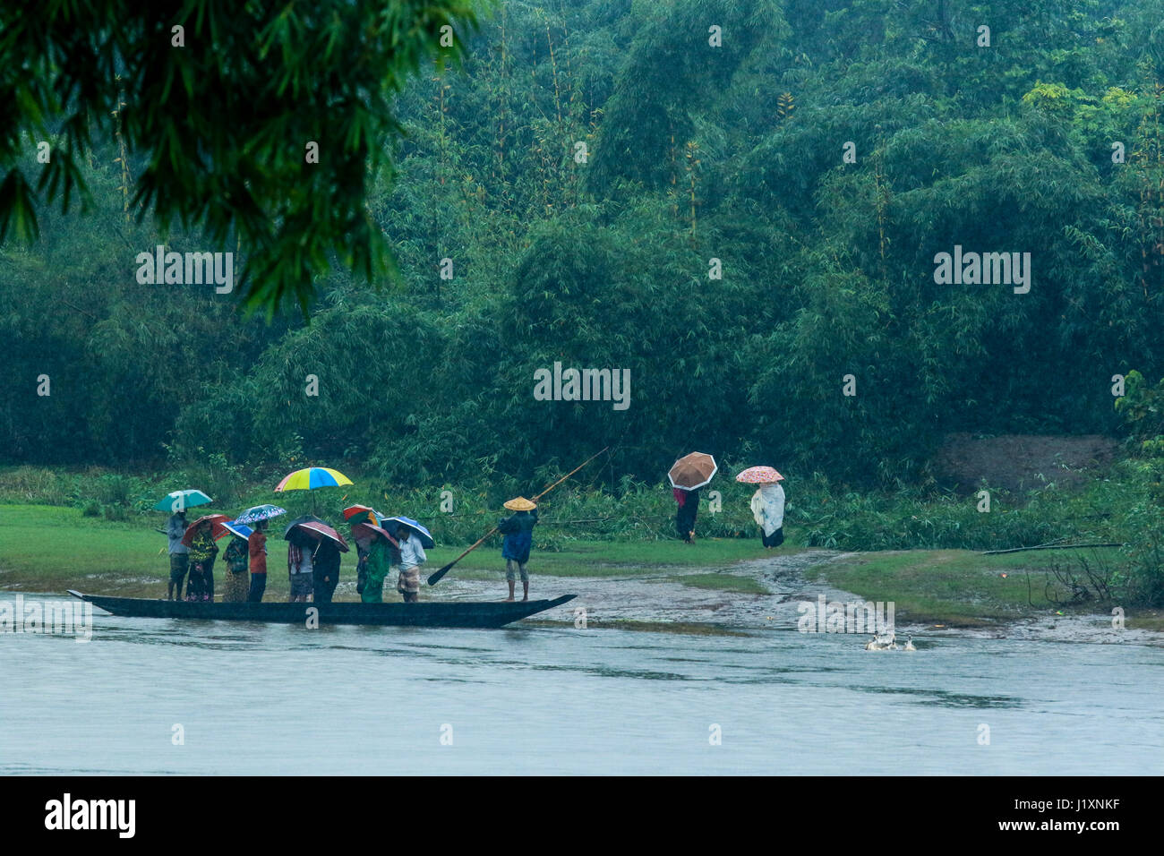 Fahrgäste überqueren Sie den Fluss ver¬ per Boot während die Regenfälle am Gowainghat. Sylhet, Bangladesch. Stockfoto