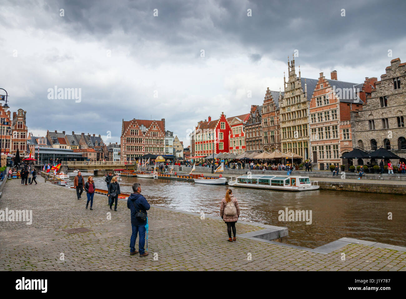 Ansicht der Graslei (Gras Quay) und der Korenlei (Mais Quay) mit mittelalterlichen Gebäuden und nicht identifizierten Touristen an einem bewölkten Tag. Gent, Belgien. Stockfoto