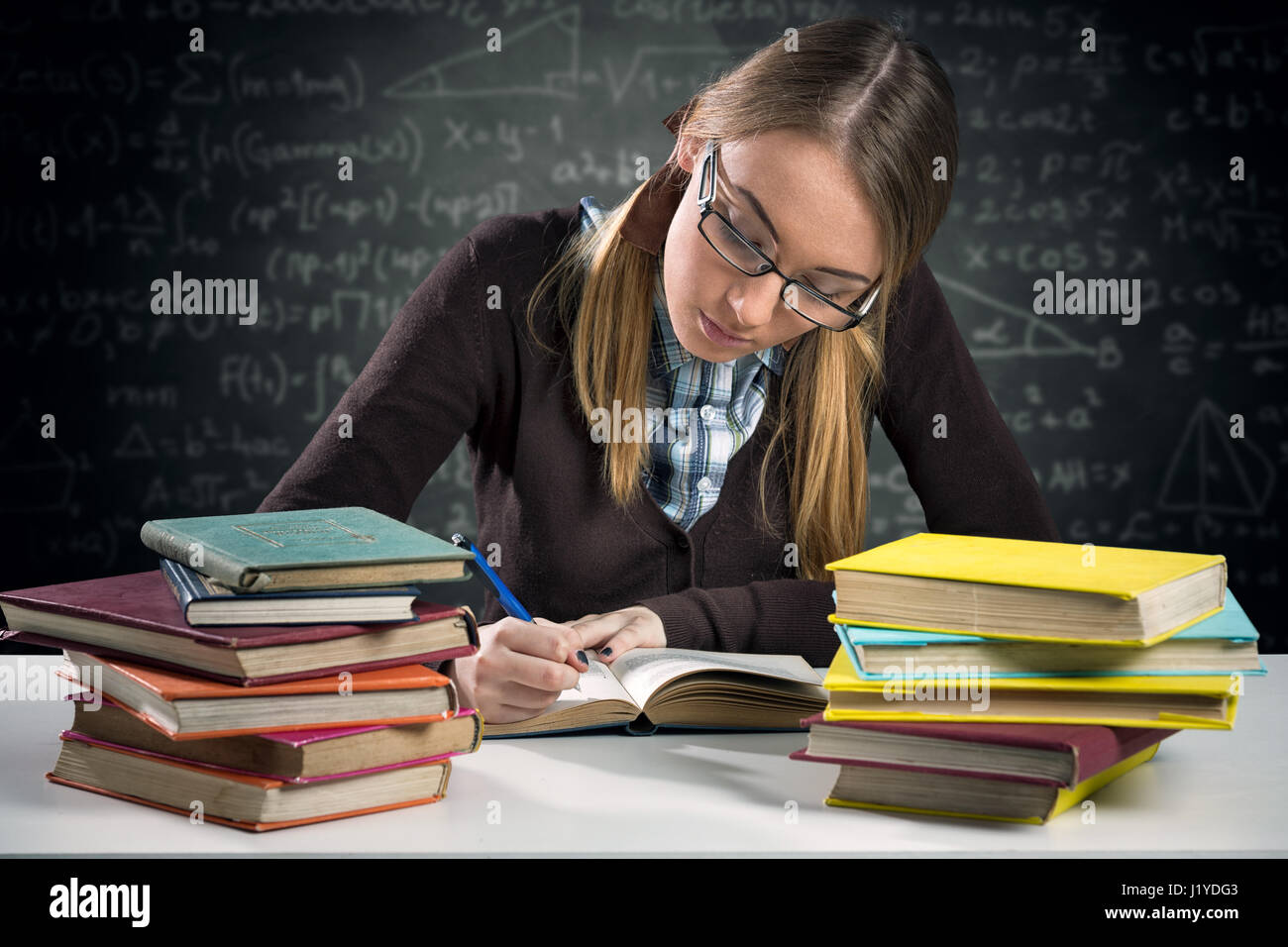 junges Mädchen arbeiten Hausaufgaben am Schreibtisch Stockfoto