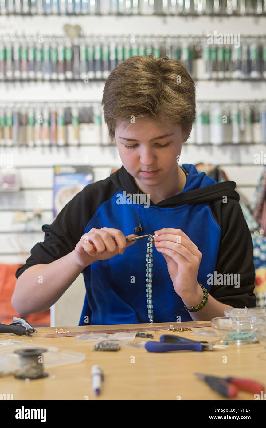 Ein Teenager High School Schüler arbeiten in Teilzeit in der Mutter-Schmuck-Shop. Stockfoto