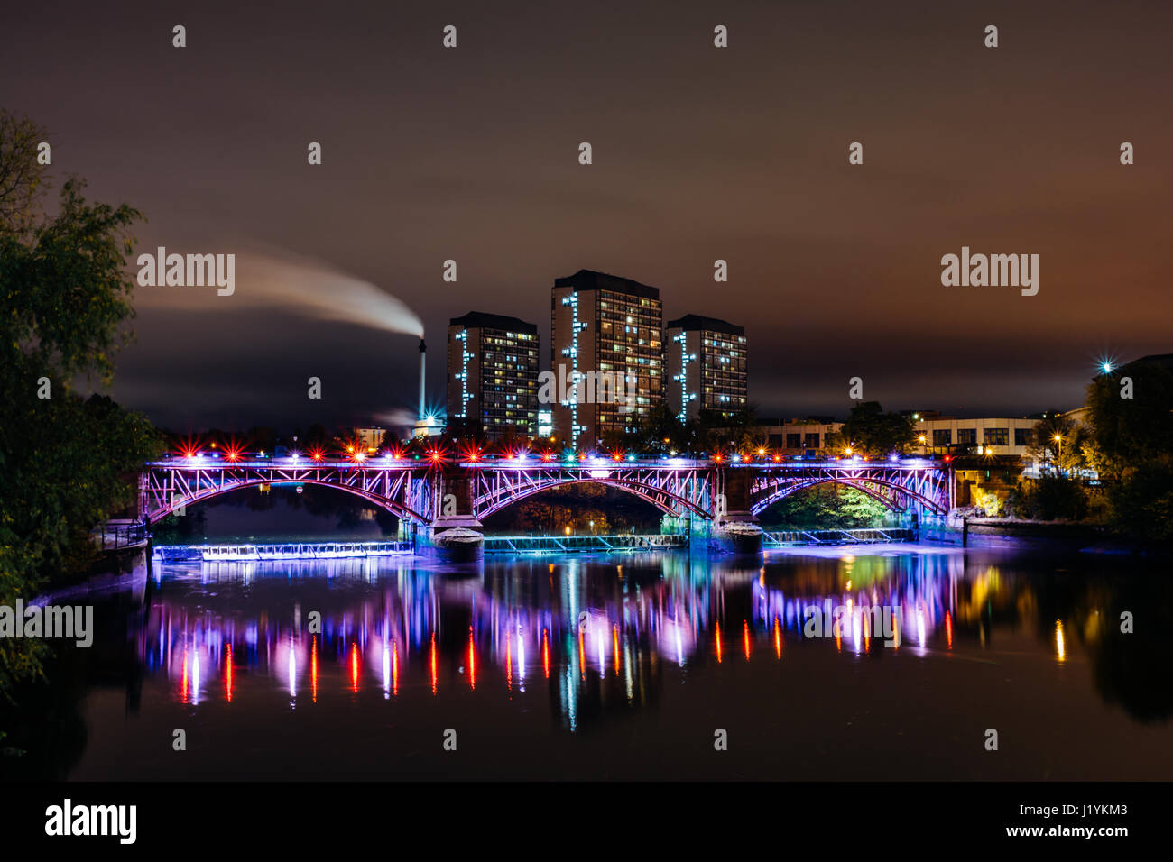 Die rohrbrücke und Gezeiten Wehr in Glasgow mit Tower Blocks in den gorbals und der Schornstein des Strathclyde Distillery im Hintergrund, Stockfoto