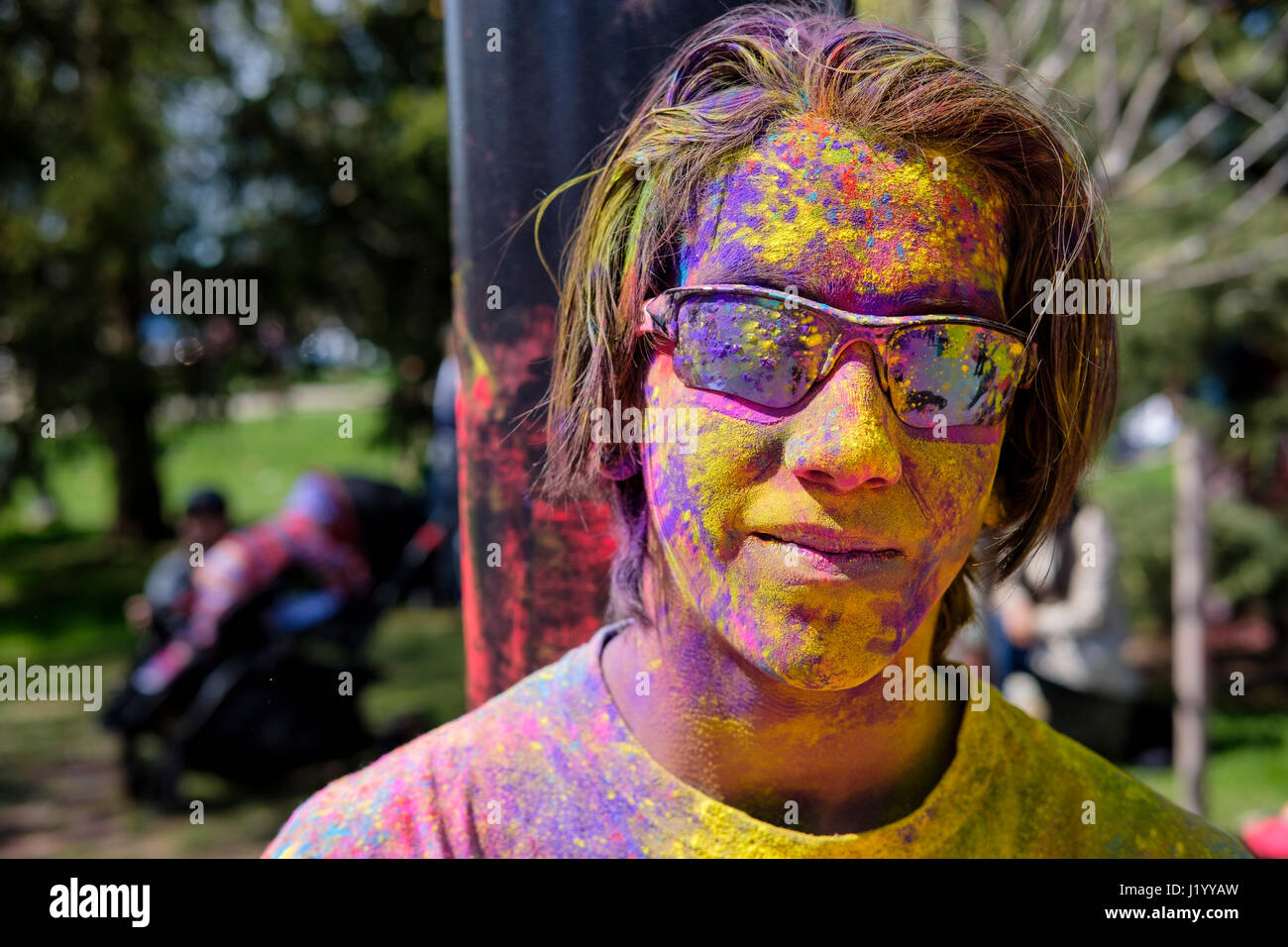 London, Ontario, Kanada, 22. April 2017. Männlichen Teenager, junge Teenager, Teen mit reflektierenden Sonnenbrille mit dem Gesicht in bunte Pulver im Victoria Park bedeckt, während das Frühlingsfest Holi, auch bekannt als Rangwali Holi, Dhuleti, Dhulandi, Phagwah oder einfach als fest der Farben, ein Hindu-Festival zur Feier der Ankunft des Frühlings in London, Ontario, Kanada. Bildnachweis: Rubens Alarcon/Alamy Live-Nachrichten. Stockfoto