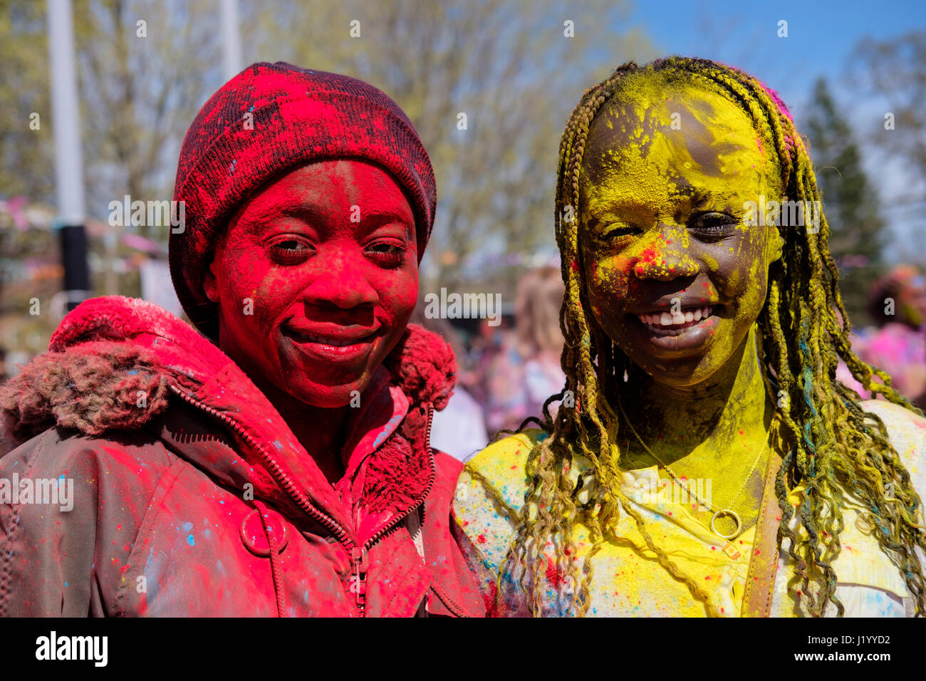 London, Ontario, Kanada, 22. April 2017. Zwei afroamerikanische Teenager, Mädchen, die mit buntem Pulver bedeckt sind und während des Holi Spring Festivals, auch bekannt als Rangwali Holi, Dhuleti, Dhulandi, Phagwah, oder einfach als Festival of Colours, einem hinduistischen Festival zur Feier des Frühlings in London, Ontario, Kanada, die Kamera im Victoria Park betrachten. Kredit: Rubens Alarcon/Alamy Live Nachrichten. Stockfoto