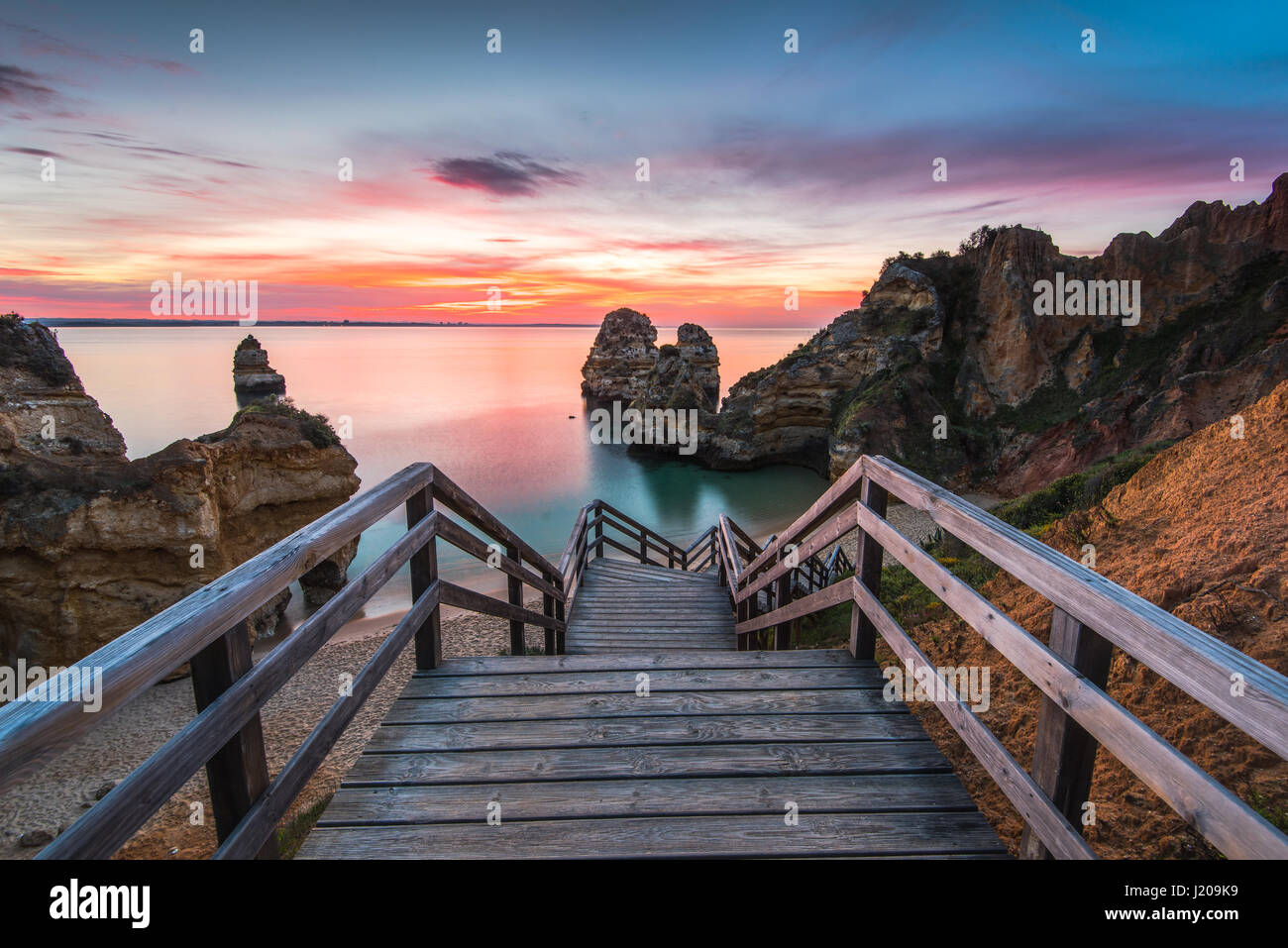 Holzsteg Fußweg zum schönen Strand Praia Camilo auf Region Küste der Algarve, Portugal bei Sonnenaufgang Stockfoto