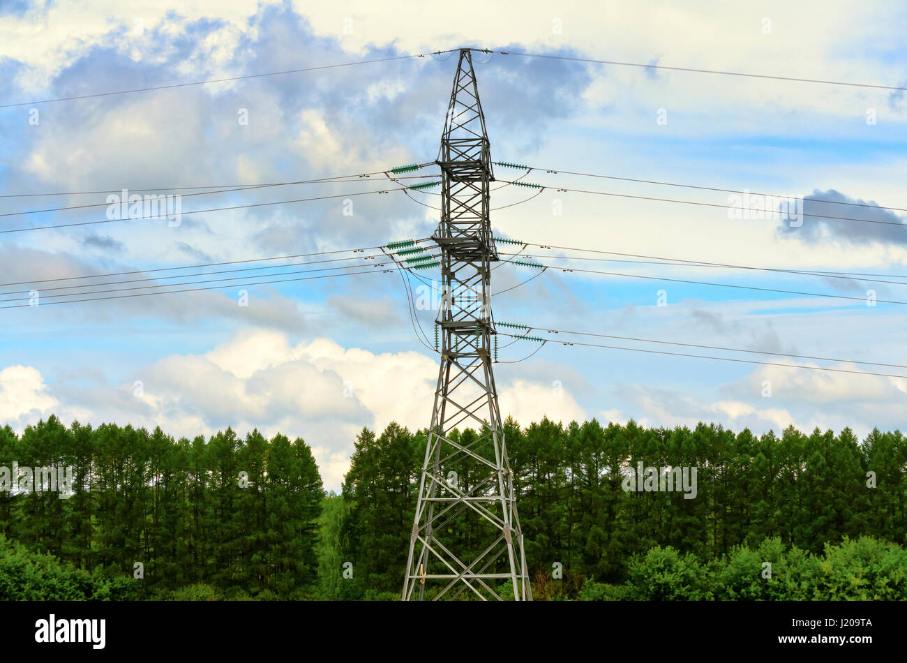Hochspannung elektrische Pylon auf einem Hintergrund von Himmel und Wald Stockfoto