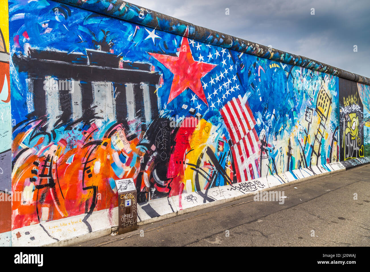 Panoramablick auf der berühmten Berliner Mauer dekoriert mit bunten Graffiti Streetart in historischen East Side Gallery auf einem stimmungsvollen bewölkten Tag im Sommer, Berlin Stockfoto