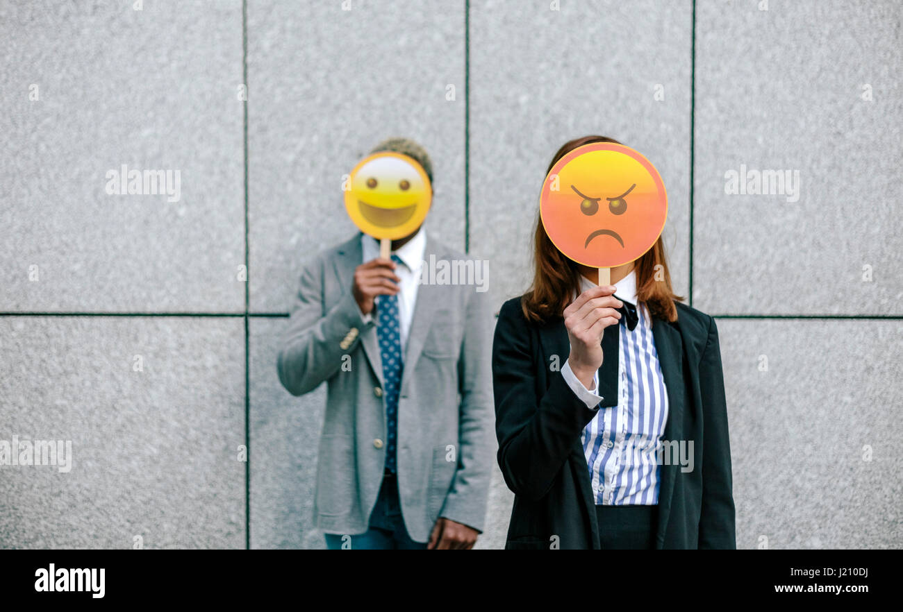 Jungunternehmer und Frau für Flächen mit Emoji-Masken Stockfoto