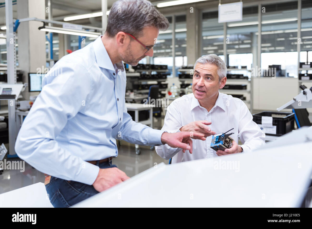 Zwei Führungskräfte diskutieren Produkt in Unternehmen Stockfoto