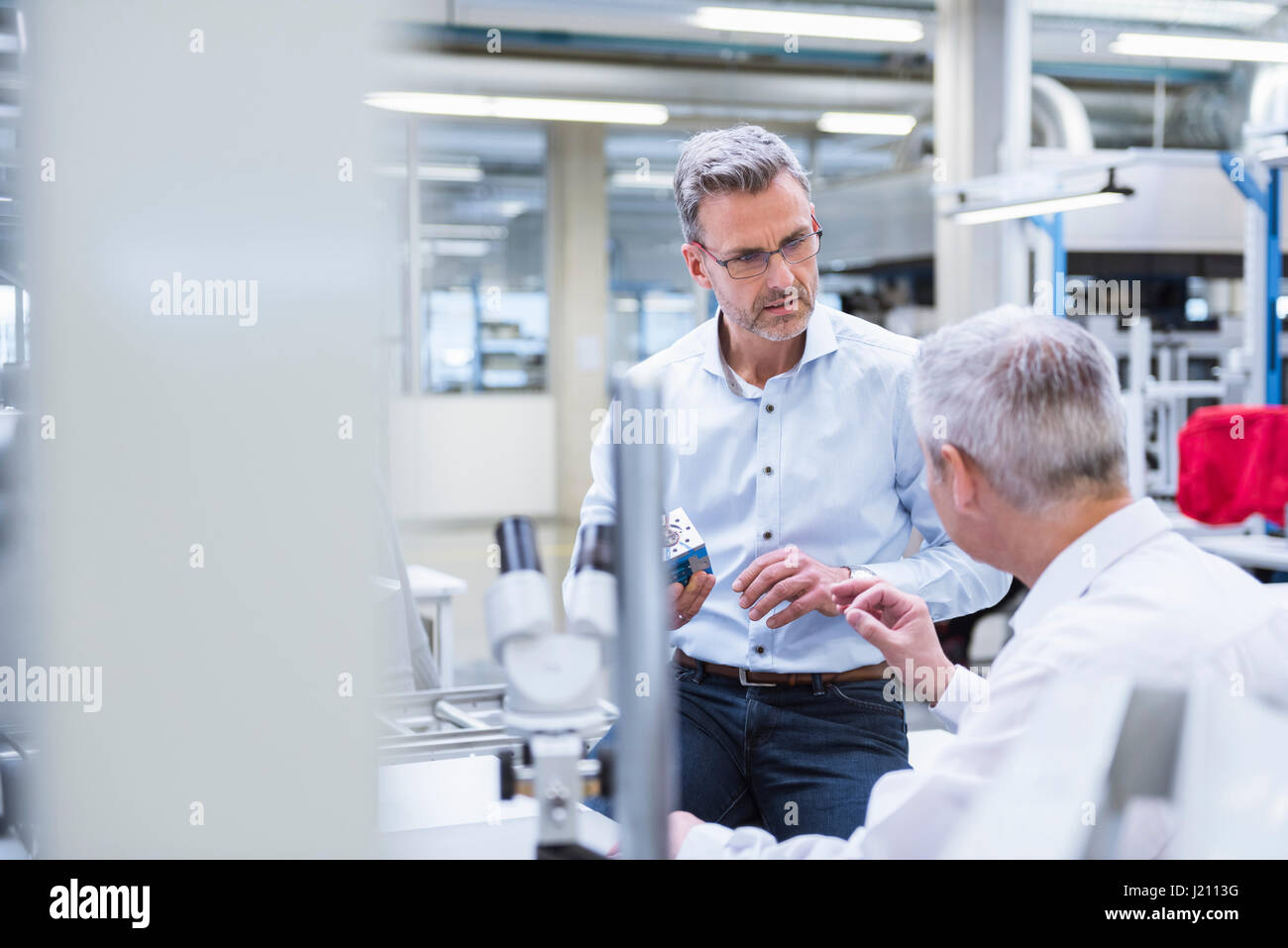 Zwei Führungskräfte diskutieren Produkt in Unternehmen Stockfoto