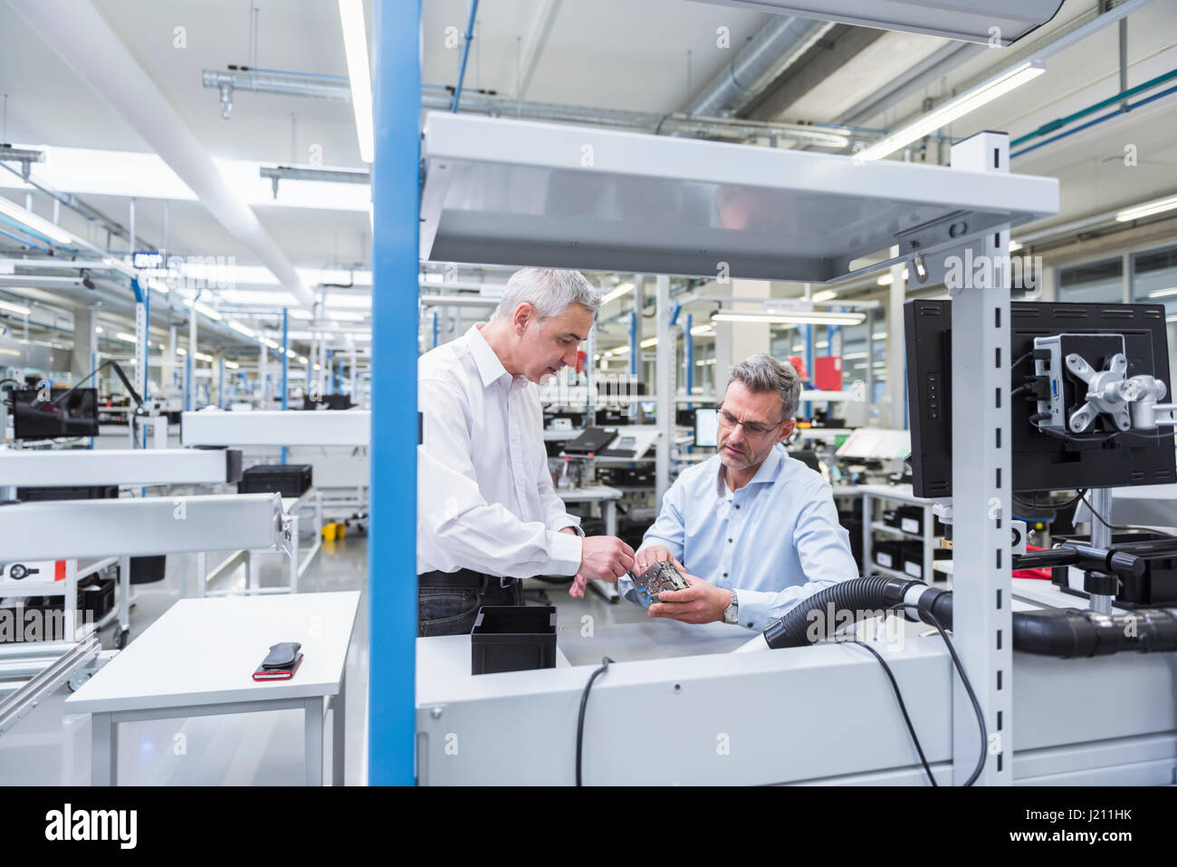 Zwei Führungskräfte diskutieren Produkt in Unternehmen Stockfoto